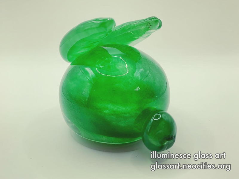 A front view of a jade green, round rabbit.